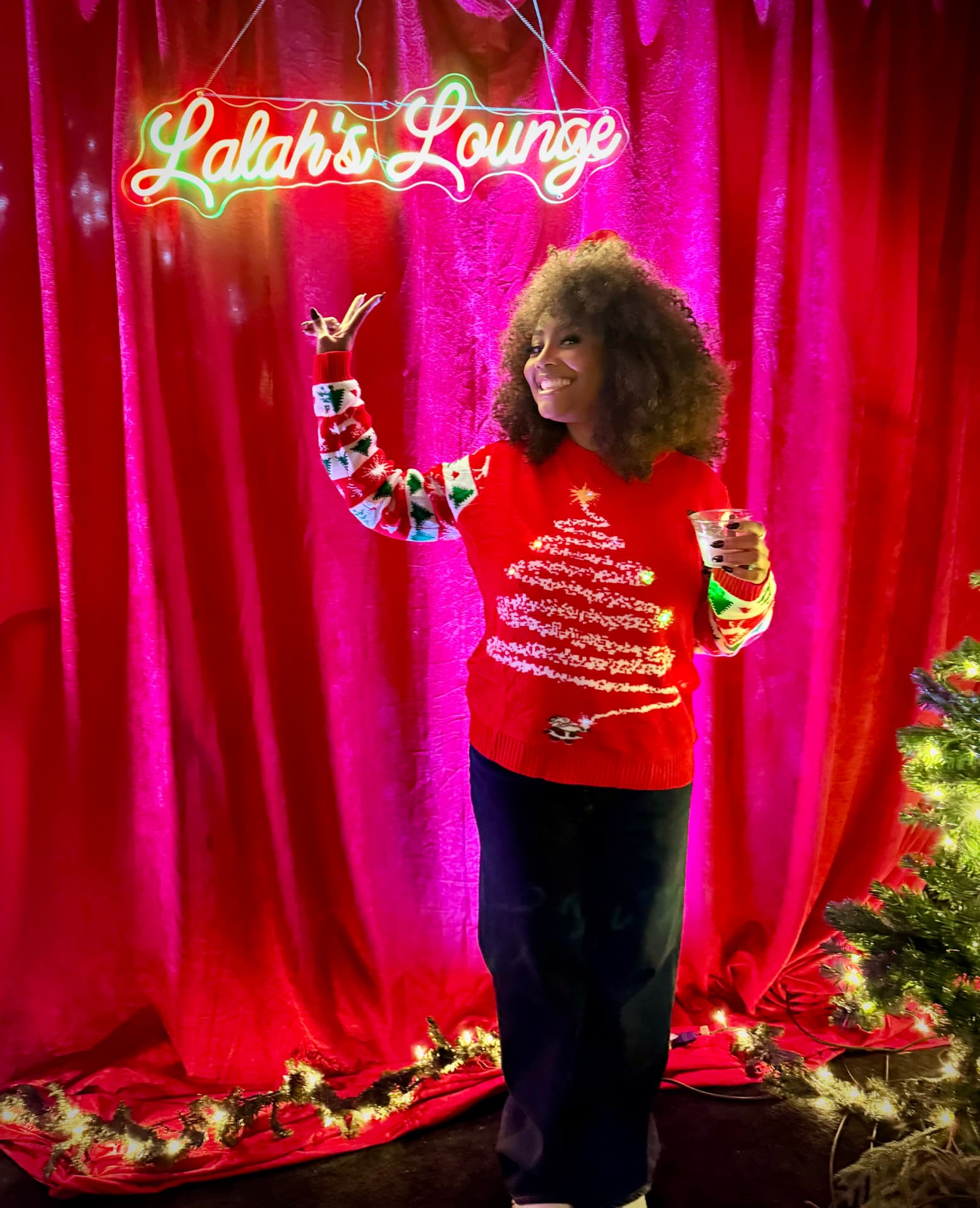 A guest celebrating in front of the Lalah's Lounge neon sign